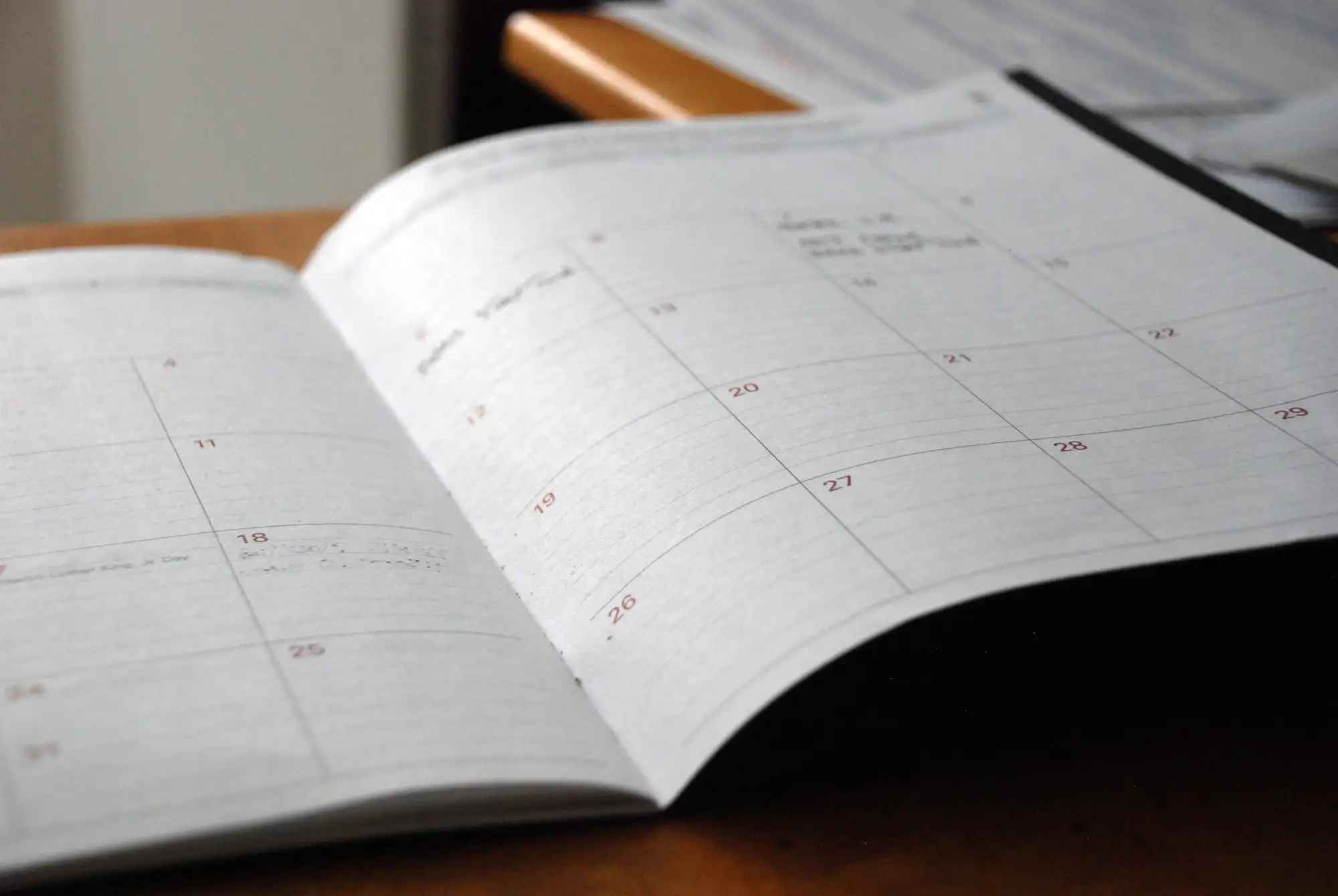 Opslået månedskalender ligger på et træbord